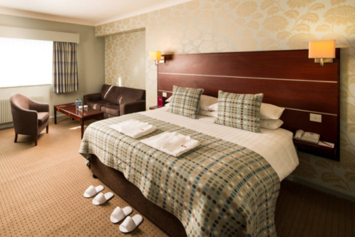 Angled view of Double bed, desk, HDTV, slippers and dressing gowns in a Privilege Room at Mercure Hotels