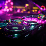 DJ console desk at party, bright pink party lights