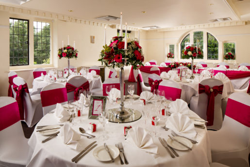 The Park Avenue Room set up for wedding breakfast, white chairs with red ribbons