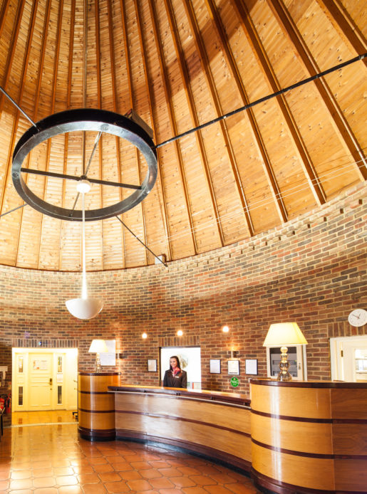 Oast house reception area at Mercure Tunbridge Wells Hotel, receptionist behind desk